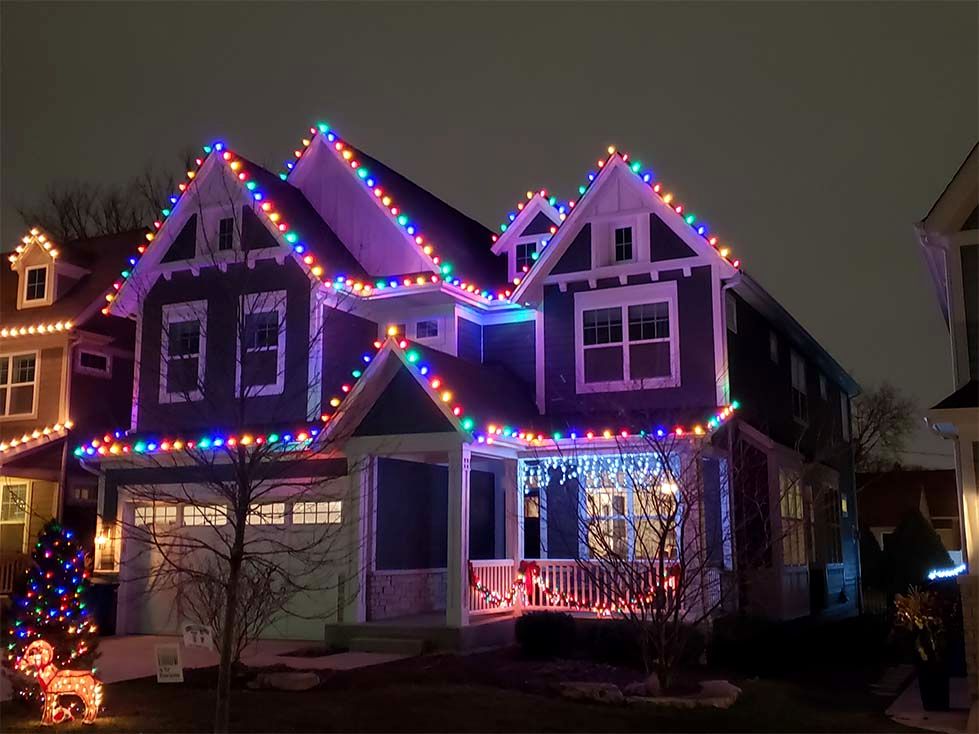Bright led holiday light strands decorating the window panes and roof peak